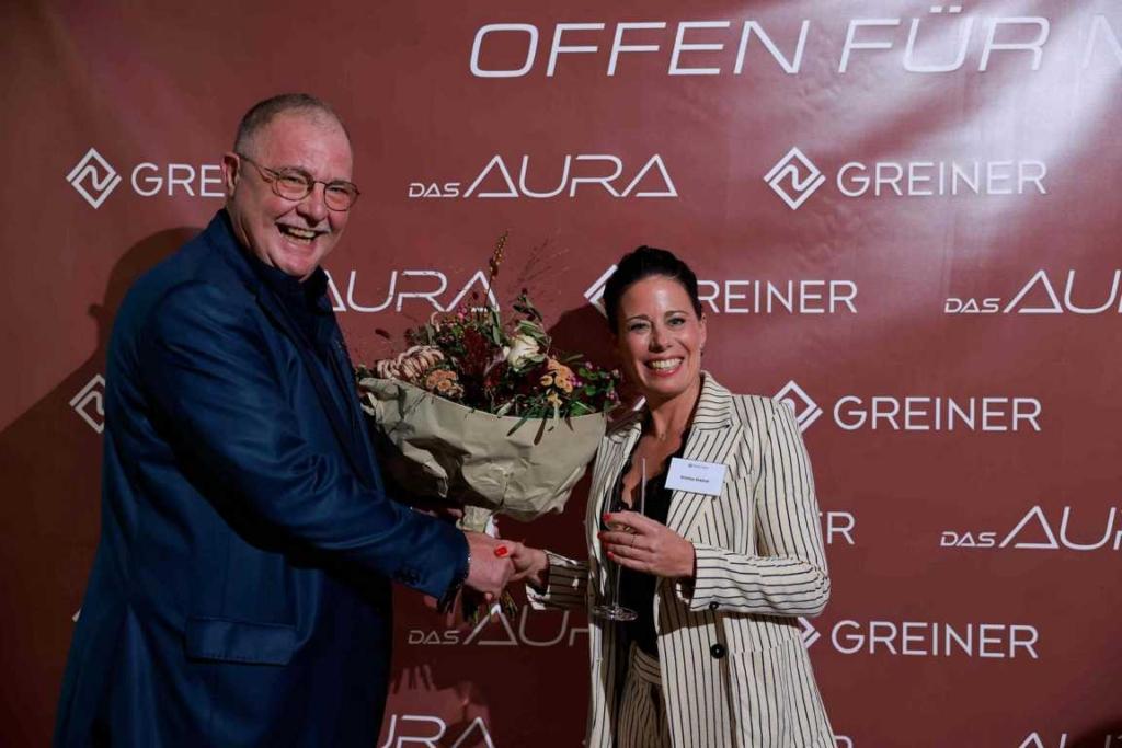 Ralf Klein überreicht Geschäftsführerin Kristina Greiner einen Blumenstrauß.